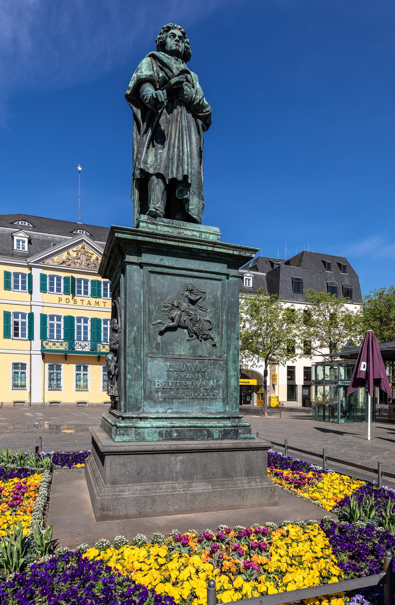 Beethoven-Denkmal auf dem Münsterplatz in Bonn mit der Münsterbasilika im Hintergrund